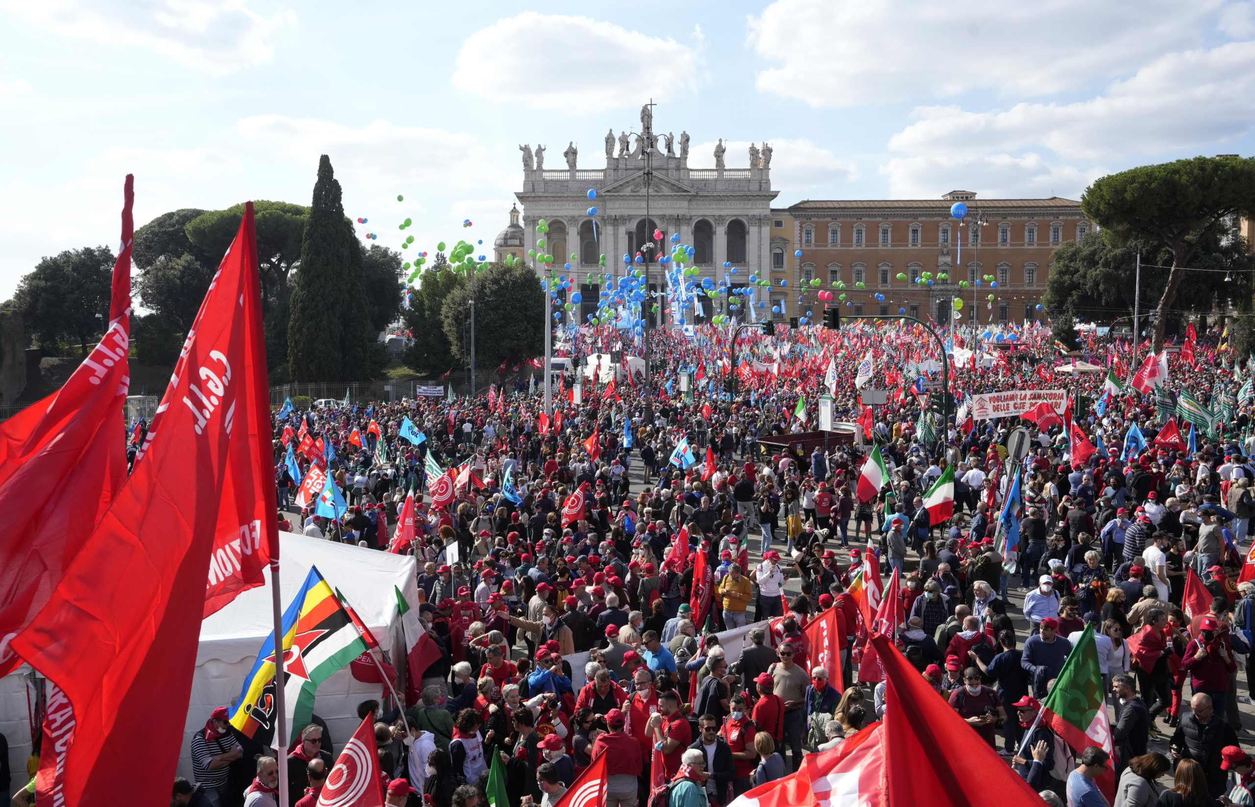 Demonstrators take part in a march organized by Italy's main labor unions, in Rome's St. John Lateran square, Saturday, Oct. 16, 2021. The march was called a week after protesters, armed with sticks and metal bars, smashed their way into the headquarters of CGIL, a left-leaning union, and trashed its office, during a demonstration to protest a government rule requiring COVID-19 vaccines or negative tests for workers to enter their offices. (AP Photo/Andrew Medichini)