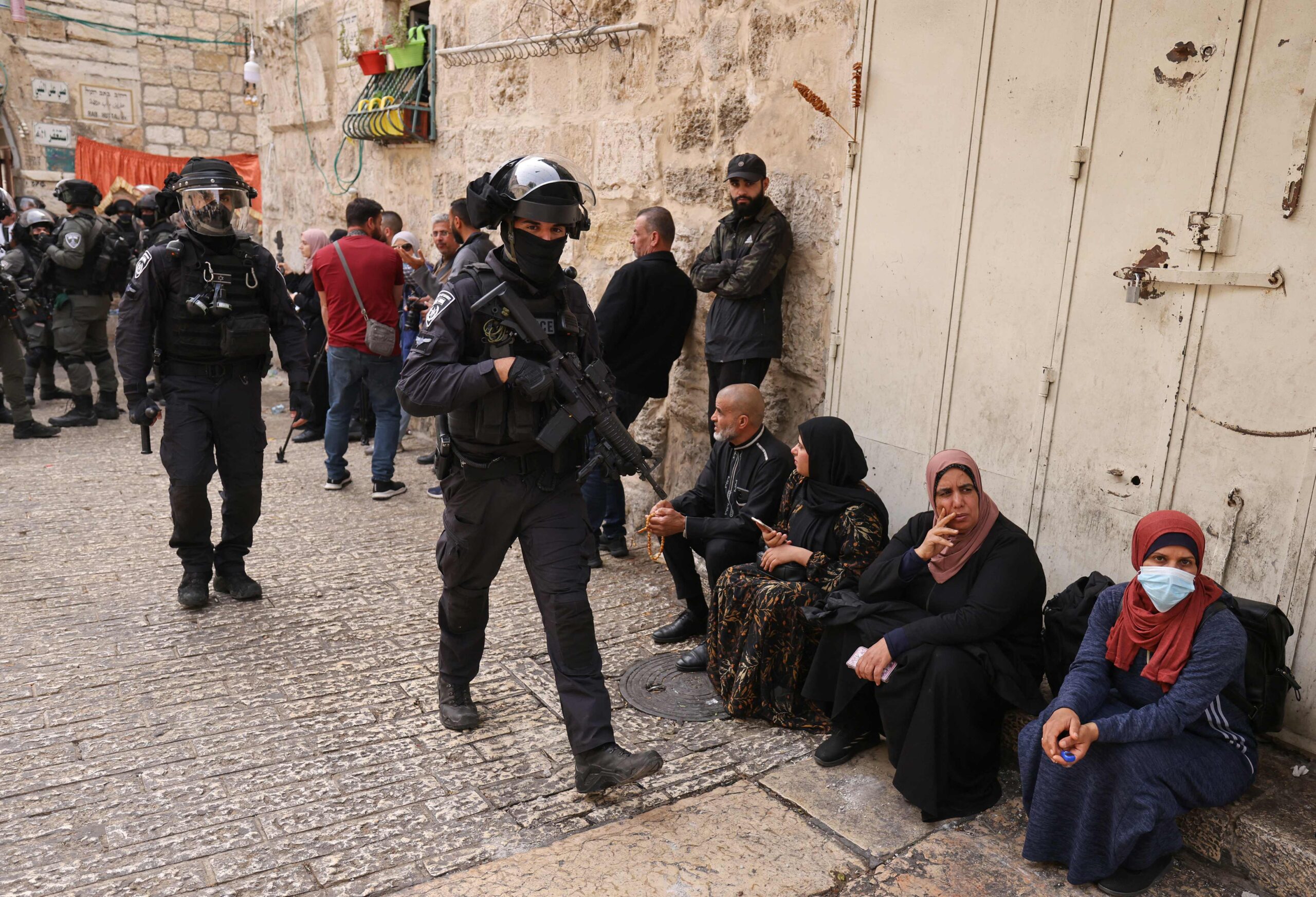 Israeli border police patrol in front of the Lion's Gate in Jerusalem's Old City, as Palestinians wait to be allowed to enter the al-Aqsa mosque compound, on April 17, 2022. (Photo by AHMAD GHARABLI / AFP)