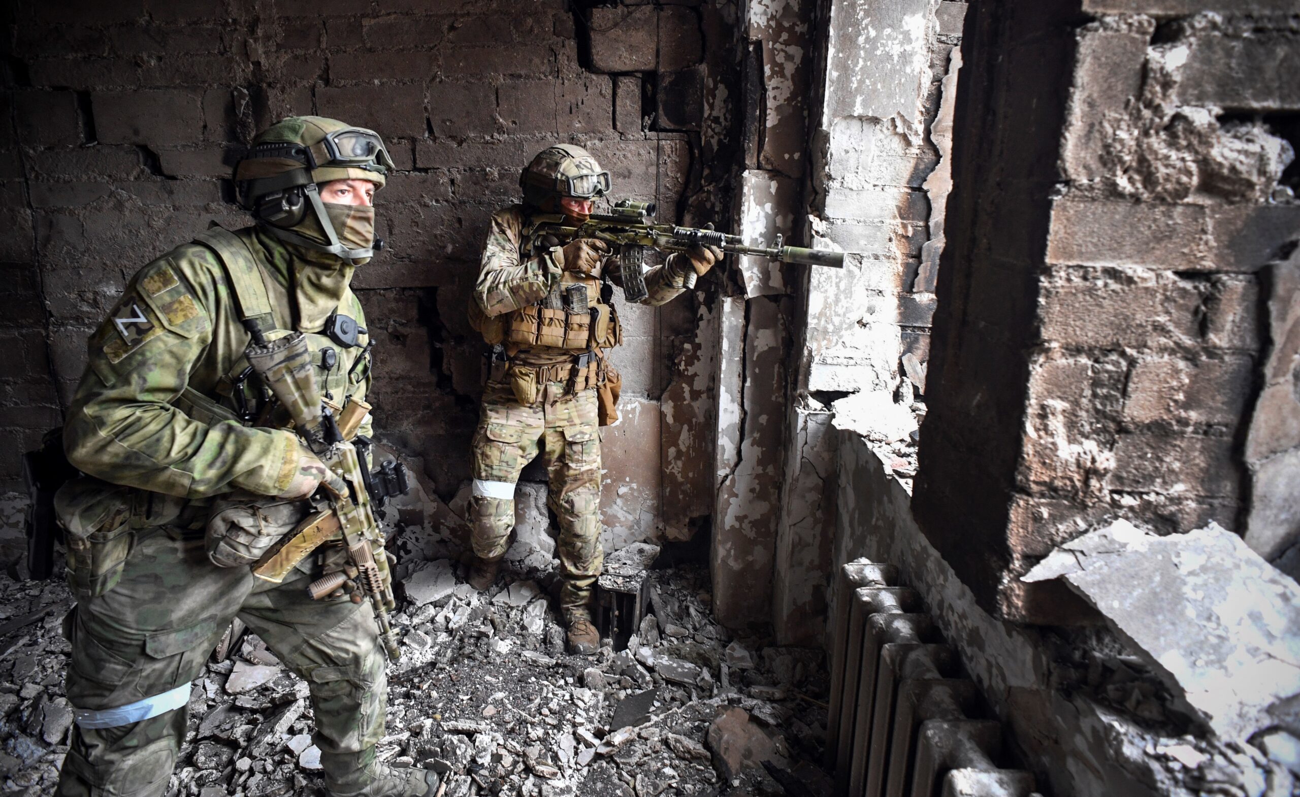 Russian soldiers patrol at the Mariupol drama theatre, bombed last March 16, on April 12, 2022 in Mariupol, as Russian troops intensify a campaign to take the strategic port city, part of an anticipated massive onslaught across eastern Ukraine, while Russia's President makes a defiant case for the war on Russia's neighbour. - *EDITOR'S NOTE: This picture was taken during a trip organized by the Russian military.* (Photo by Alexander NEMENOV / AFP)